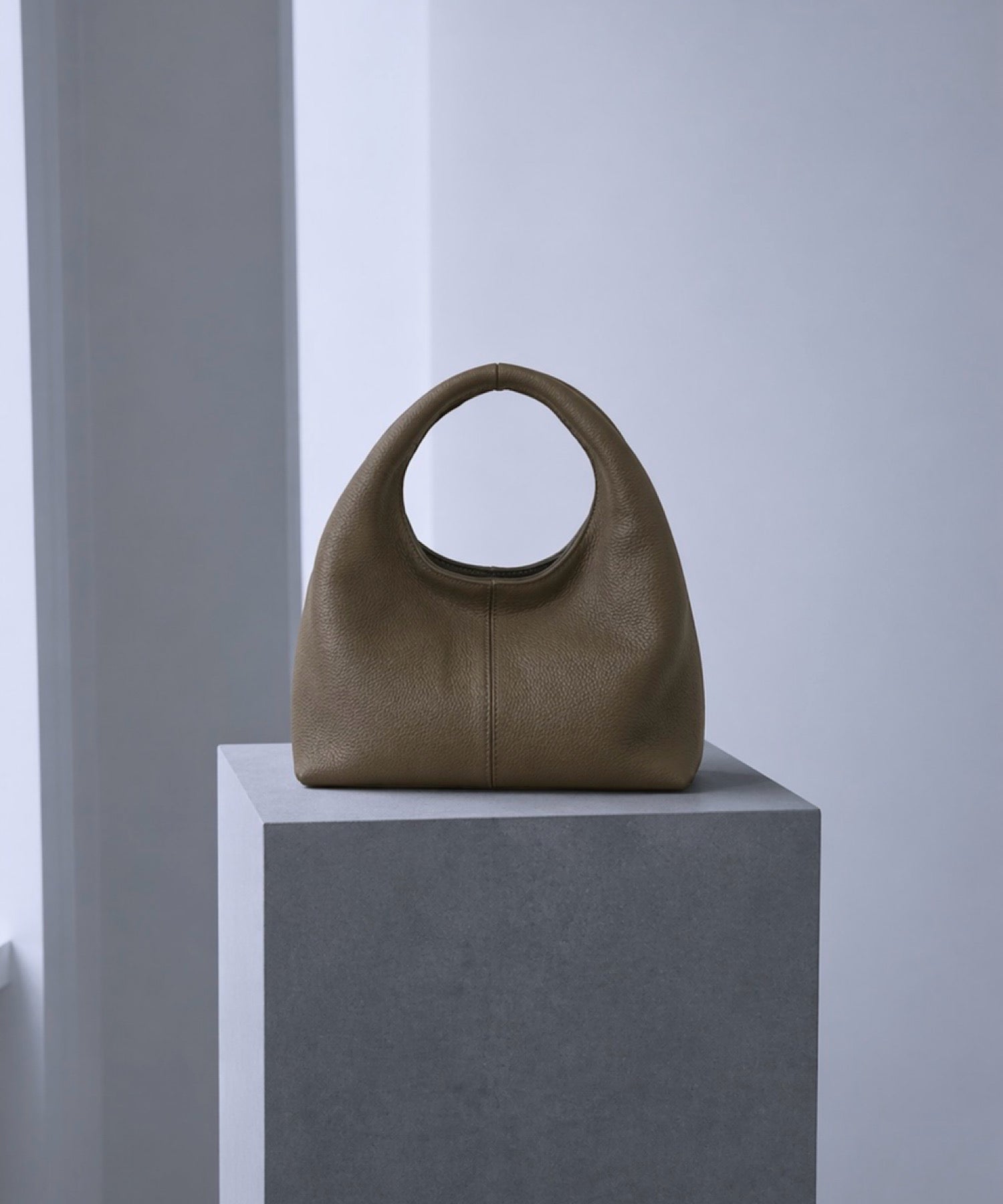 アーチハンドル レザーバッグ― フォルムとカラーで魅せる抜け感 ―